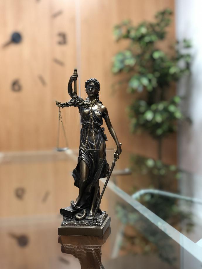 Imagen de escultura pequeña que representa la balanza de la justicia